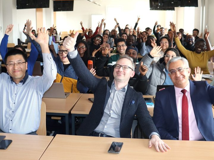 Digital Health students and faculty raising their hands during an interactive PBL session