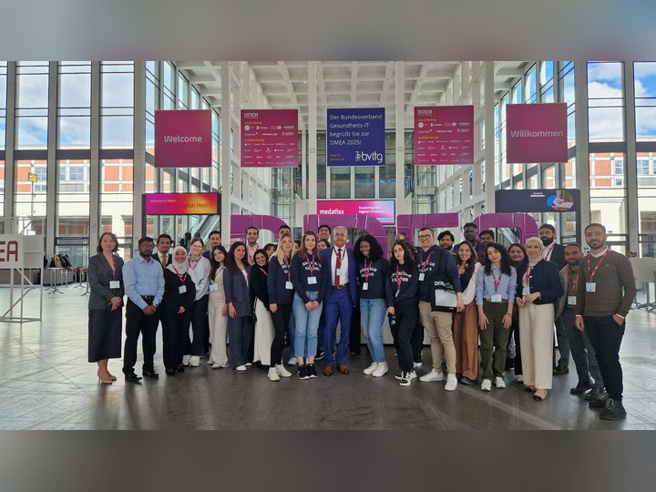 Prof. Georgi Chaltikyan with Master of Digital Health students in front of the DMEA letters at DMEA 2025