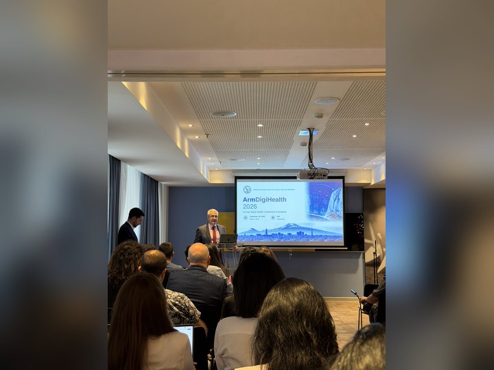 Prof. Georgi Chaltikyan speaking beneath the ArmDigiHealth-2026 conference banner