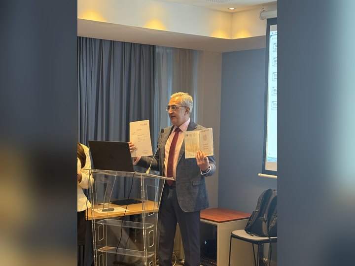 Prof. Georgi Chaltikyan displaying graduation certificates during the closing programme